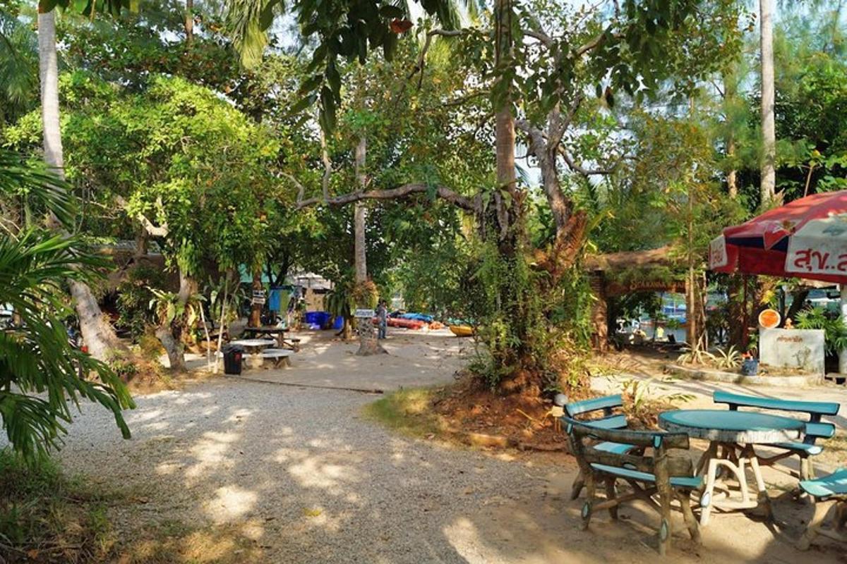 Una mesa de picnic y sillas en un parque con árboles.