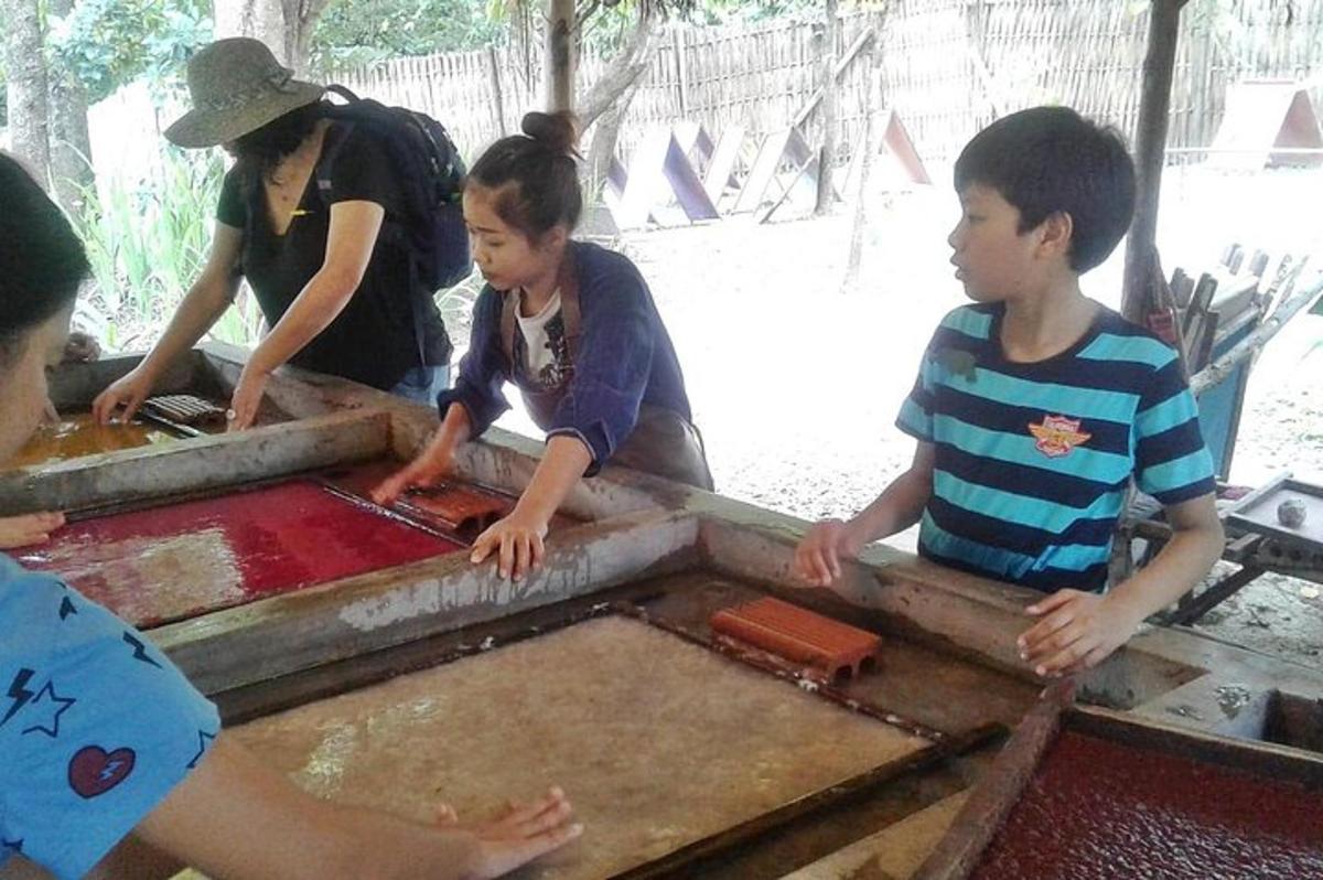 um grupo de crianças em pé ao redor de uma mesa