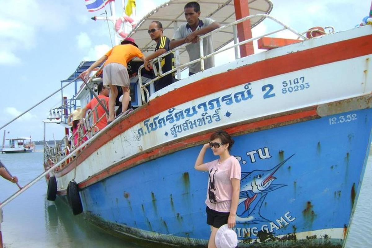 seorang wanita berdiri di samping perahu di air