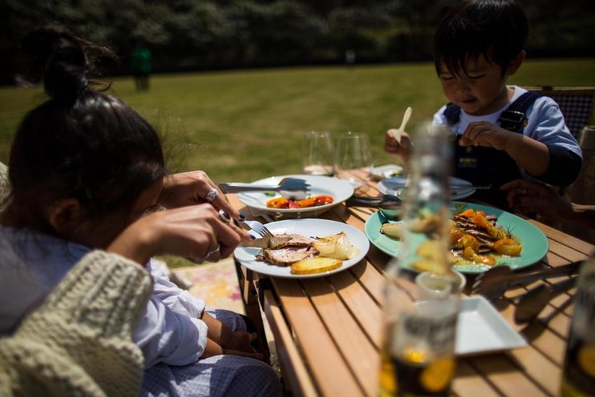 un gruppo di persone sedute a un tavolo da picnic che mangiano cibo