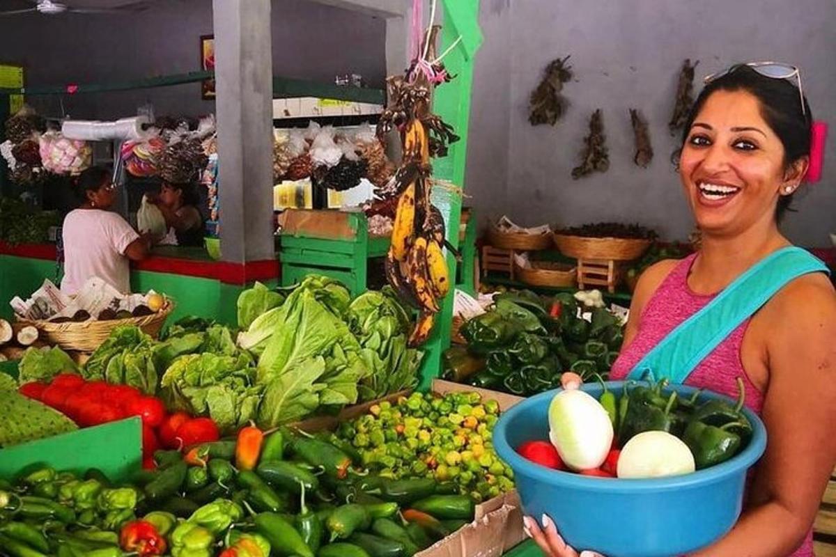 市場で野菜の入ったバケツを持っている女性