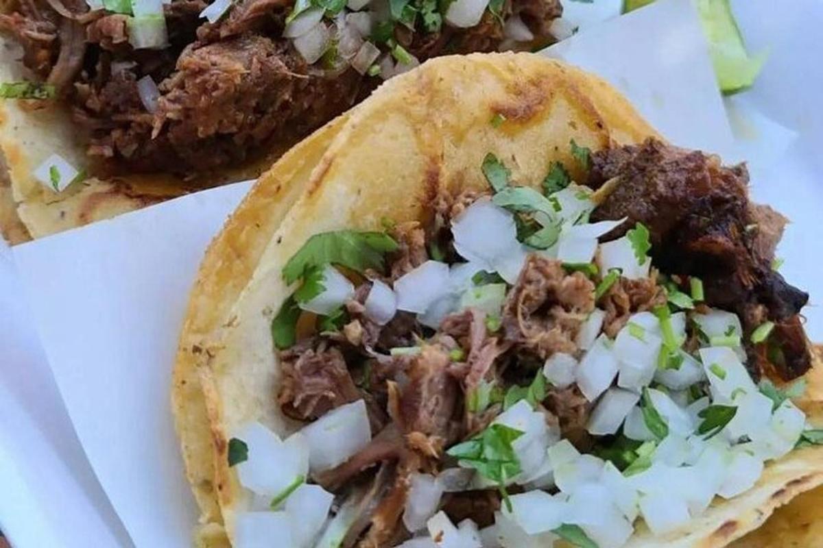 en taco med kød og løg på et bord