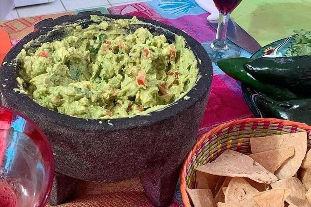 kulhollinen guacamolea pöydällä sipsien kanssa