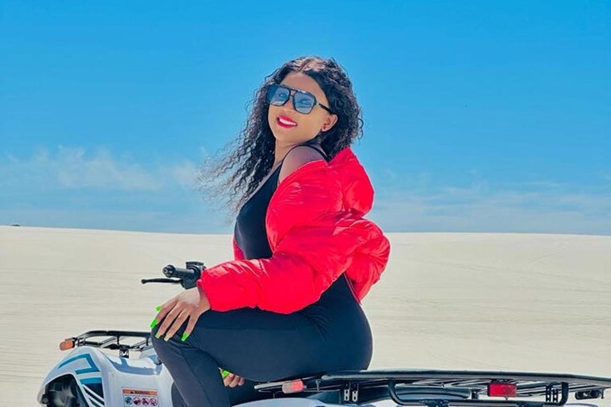 a pregnant woman sitting on a motorcycle in the desert