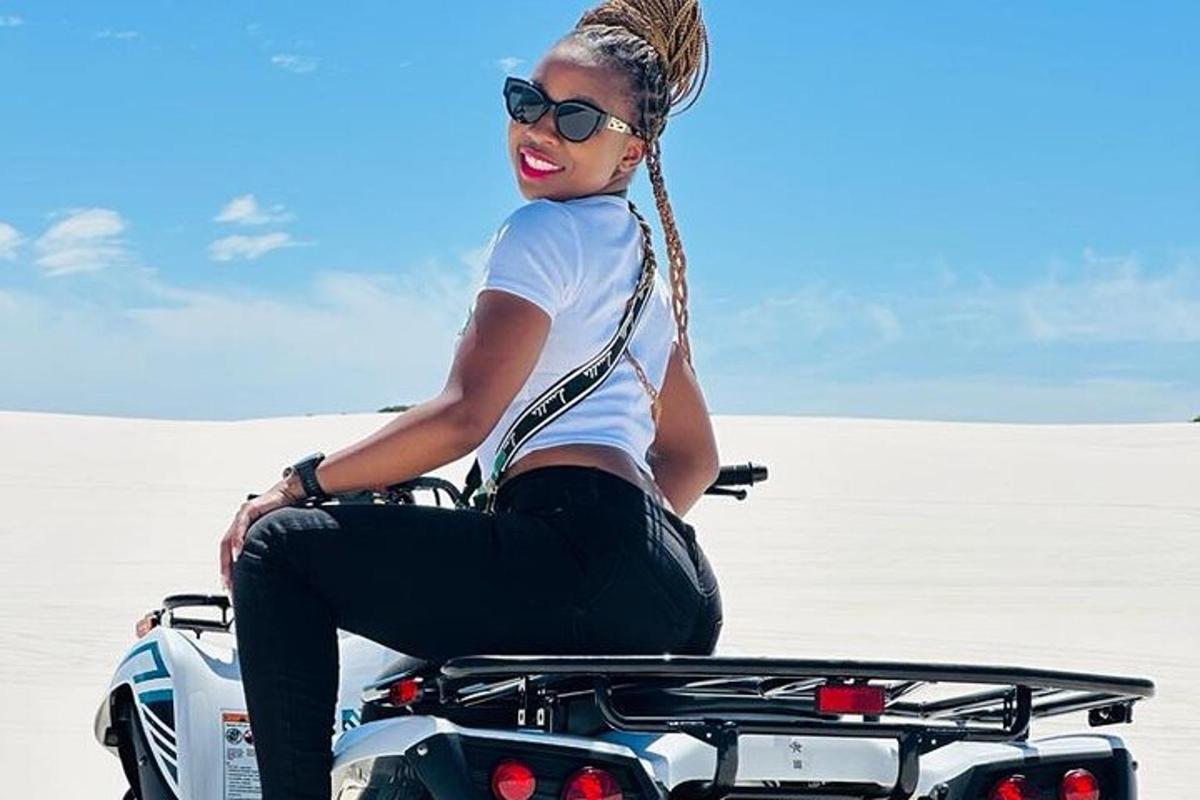 a woman sitting on a motorcycle in the desert