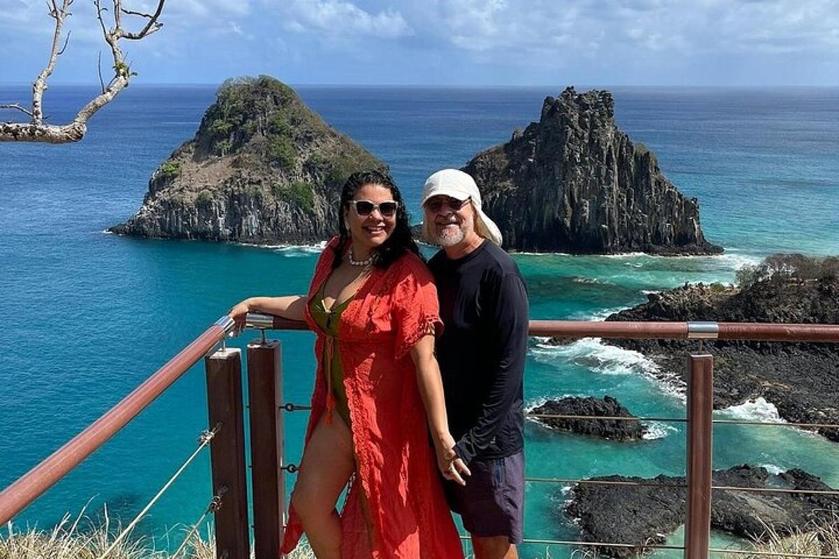 a man and a woman standing in front of the ocean