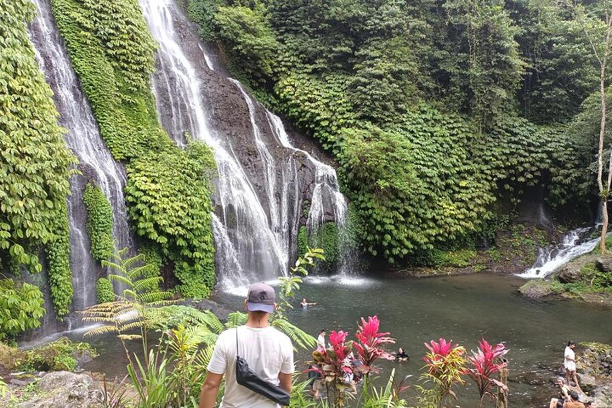 um homem parado em frente a uma cachoeira