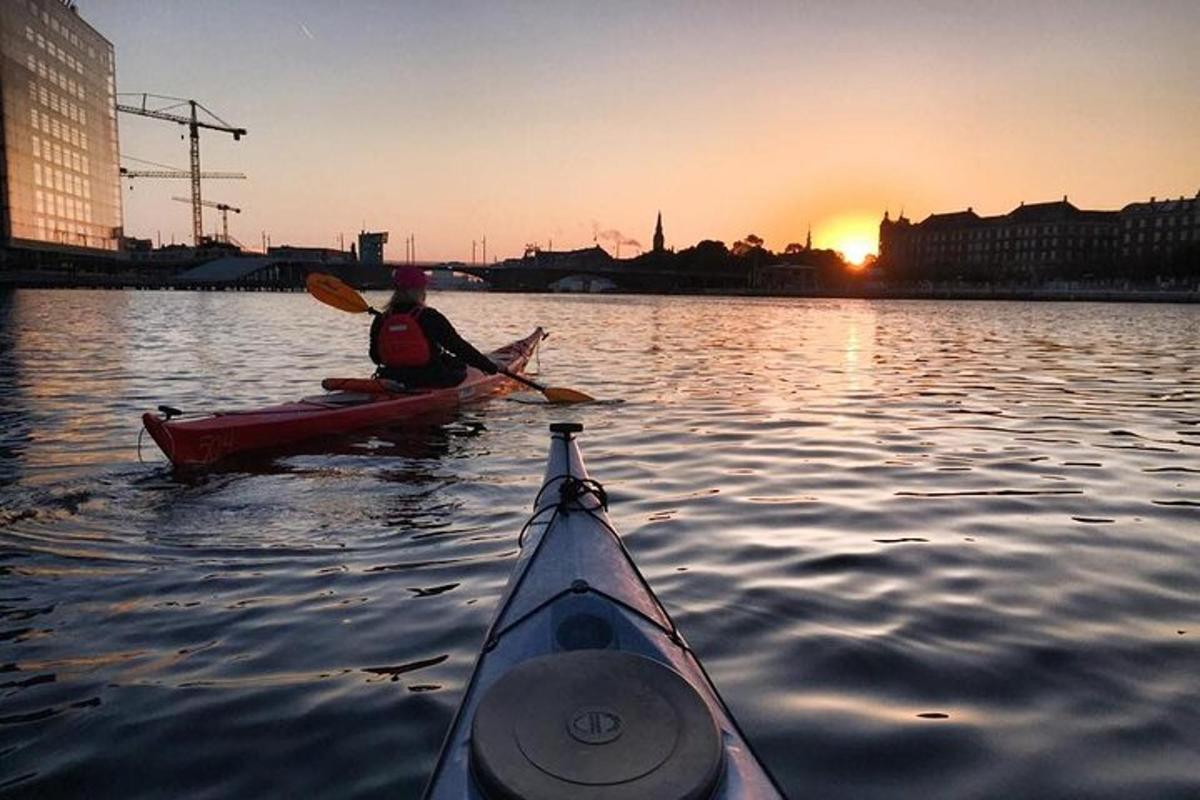 a person in a kayak on the water at sunset
