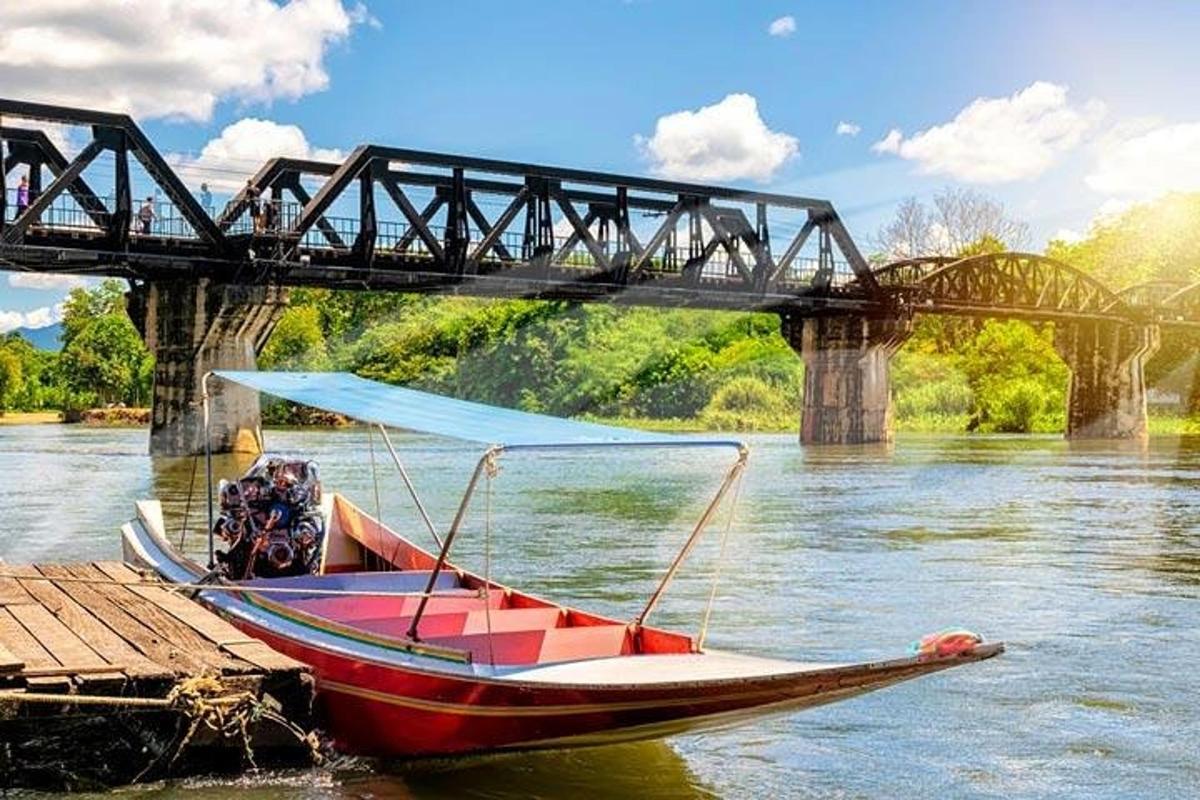 a boat sitting on the water under a bridge