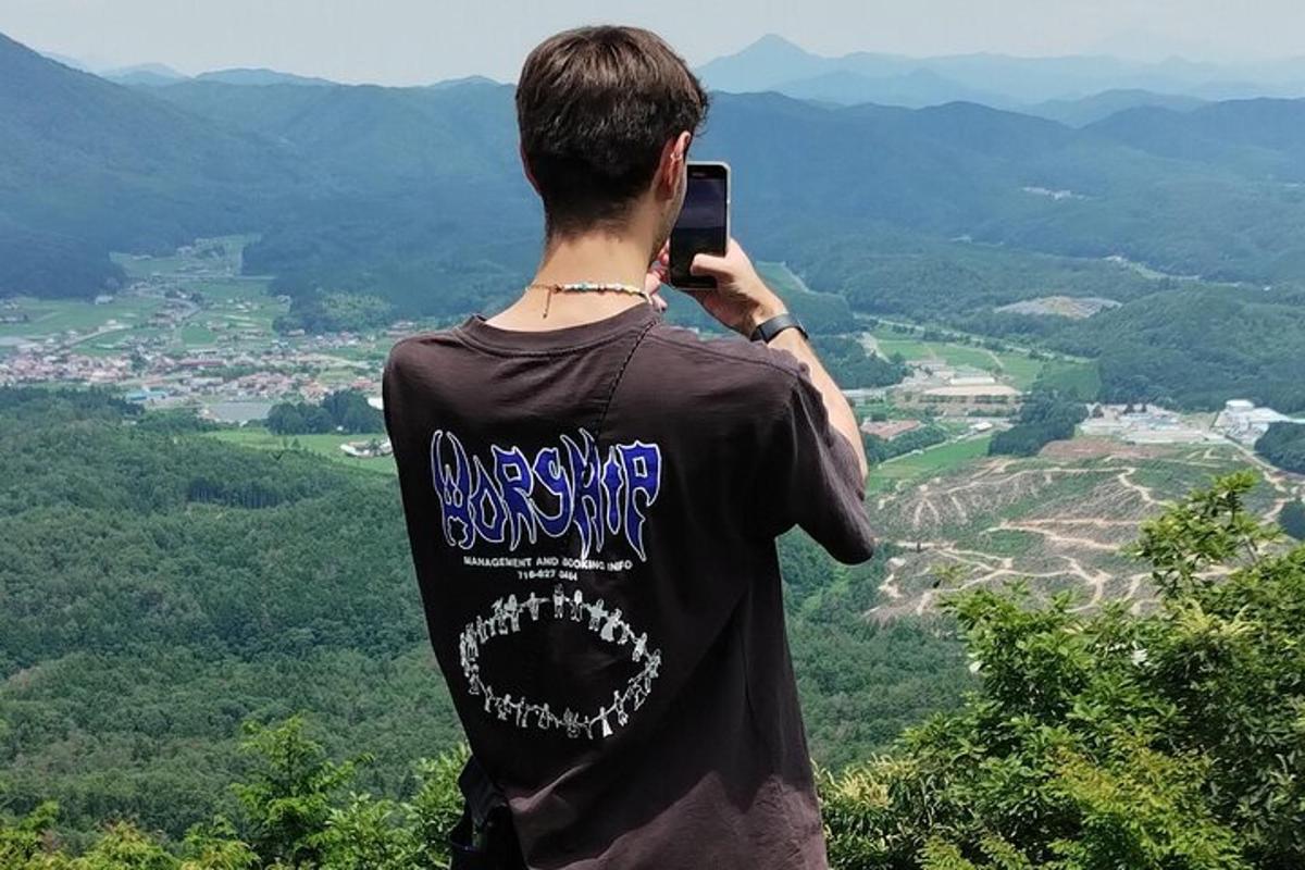 un uomo che scatta una foto di una valle con il suo cellulare