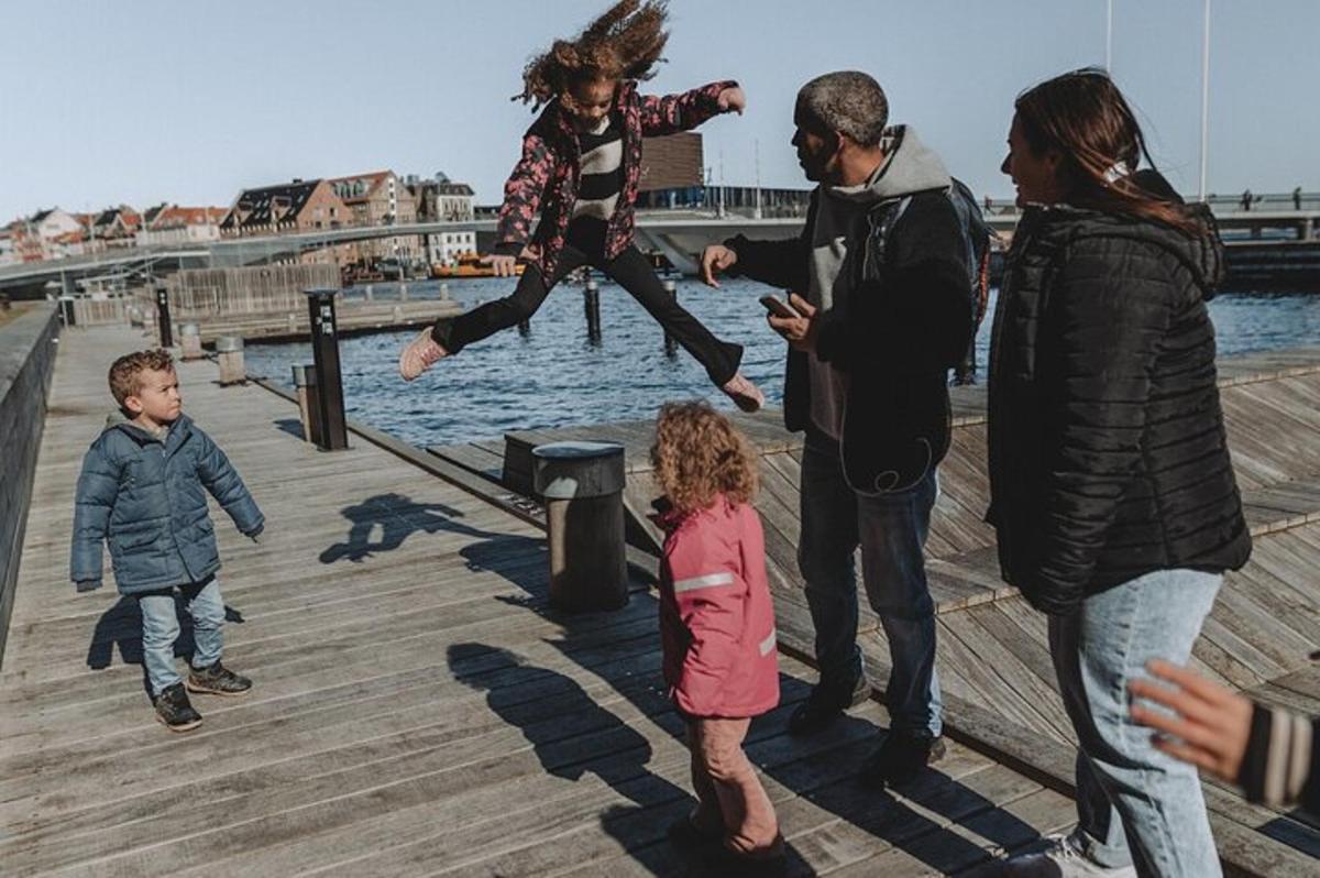 un gruppo di persone che gioca con una bambina su un molo