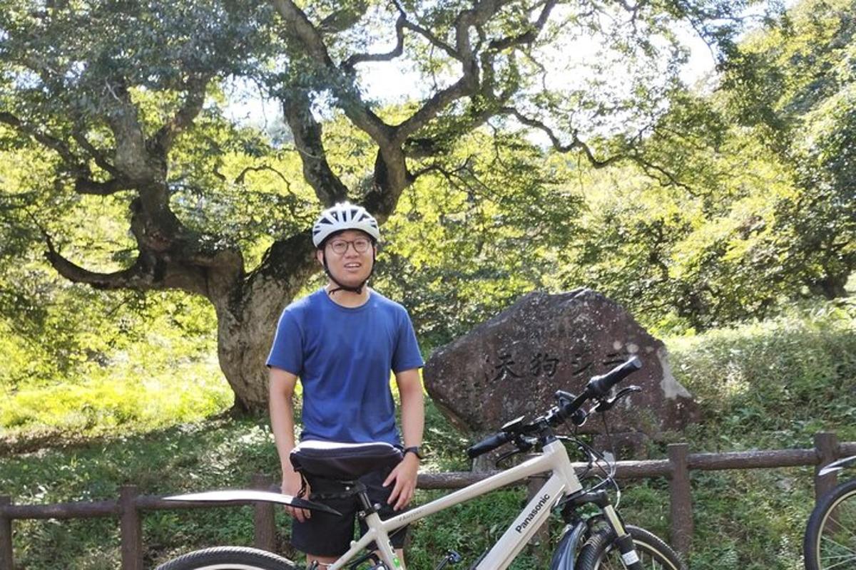 un uomo in piedi accanto a una bicicletta accanto a una recinzione