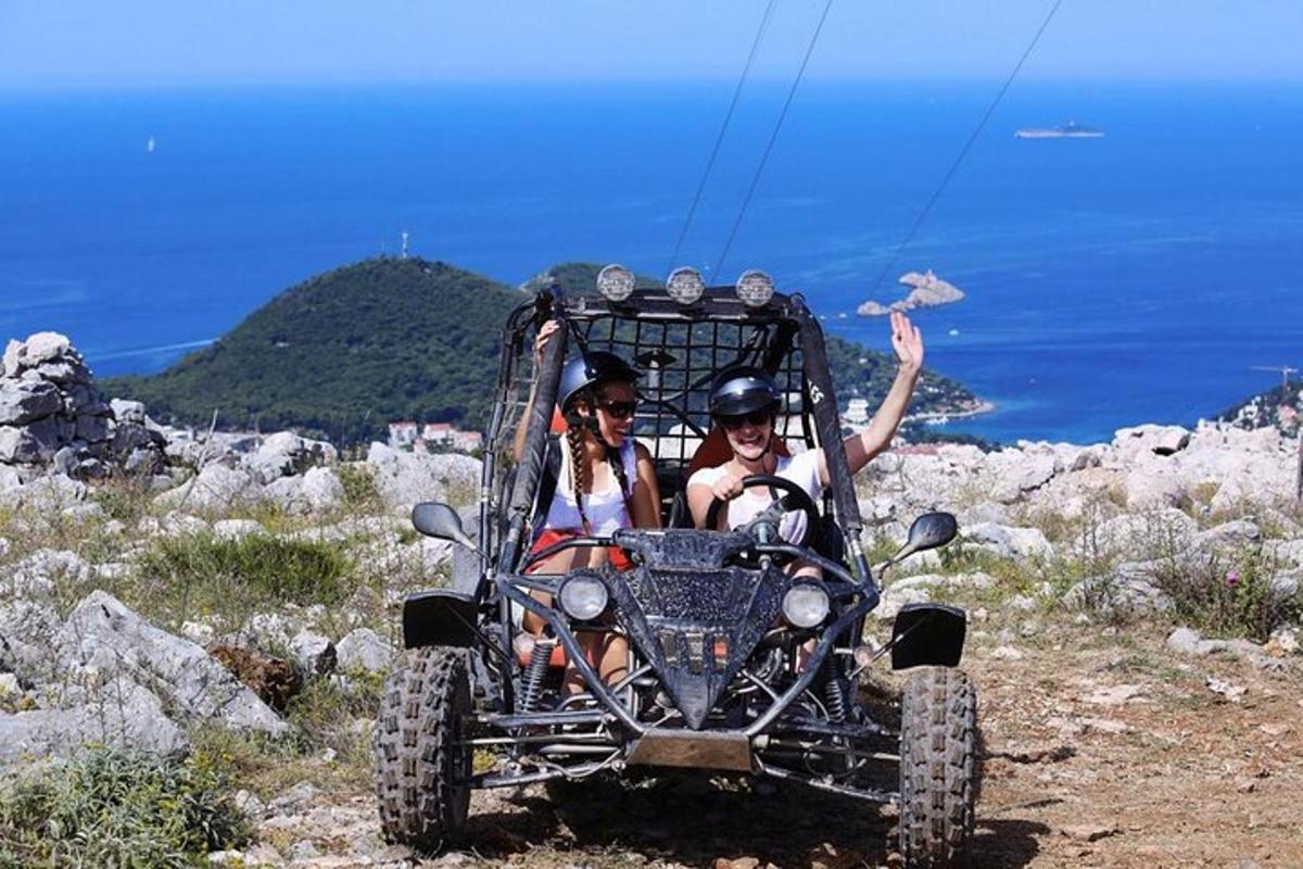 Dos personas en un vehículo de cuatro ruedas en una montaña