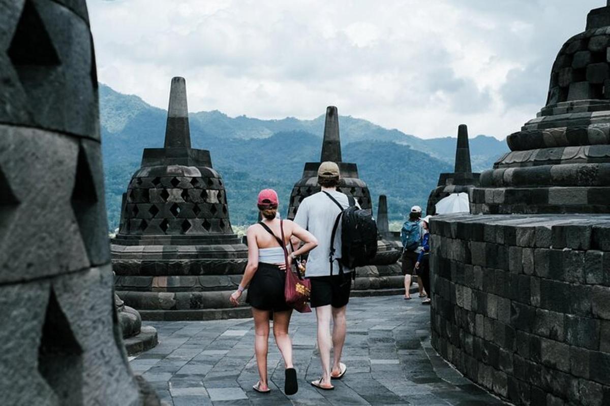 seorang lelaki dan seorang wanita berjalan di atas runtuhan kuil