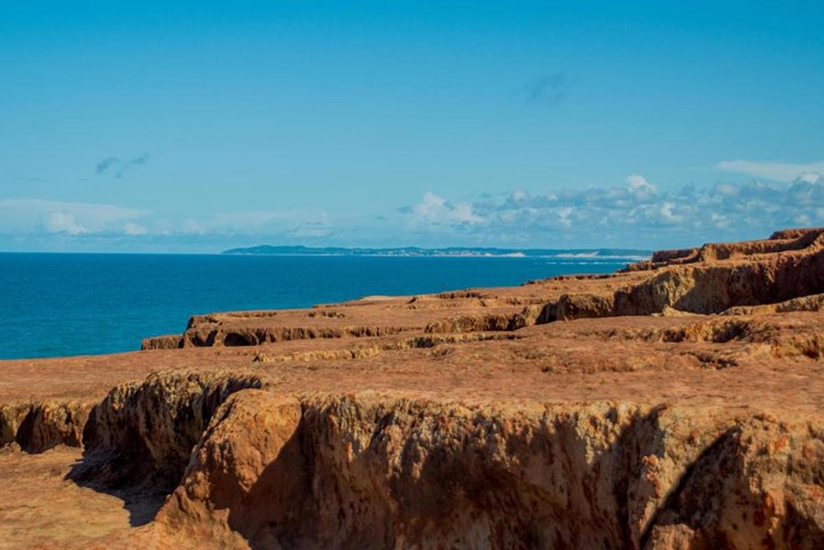 a view of the ocean from a rocky hill