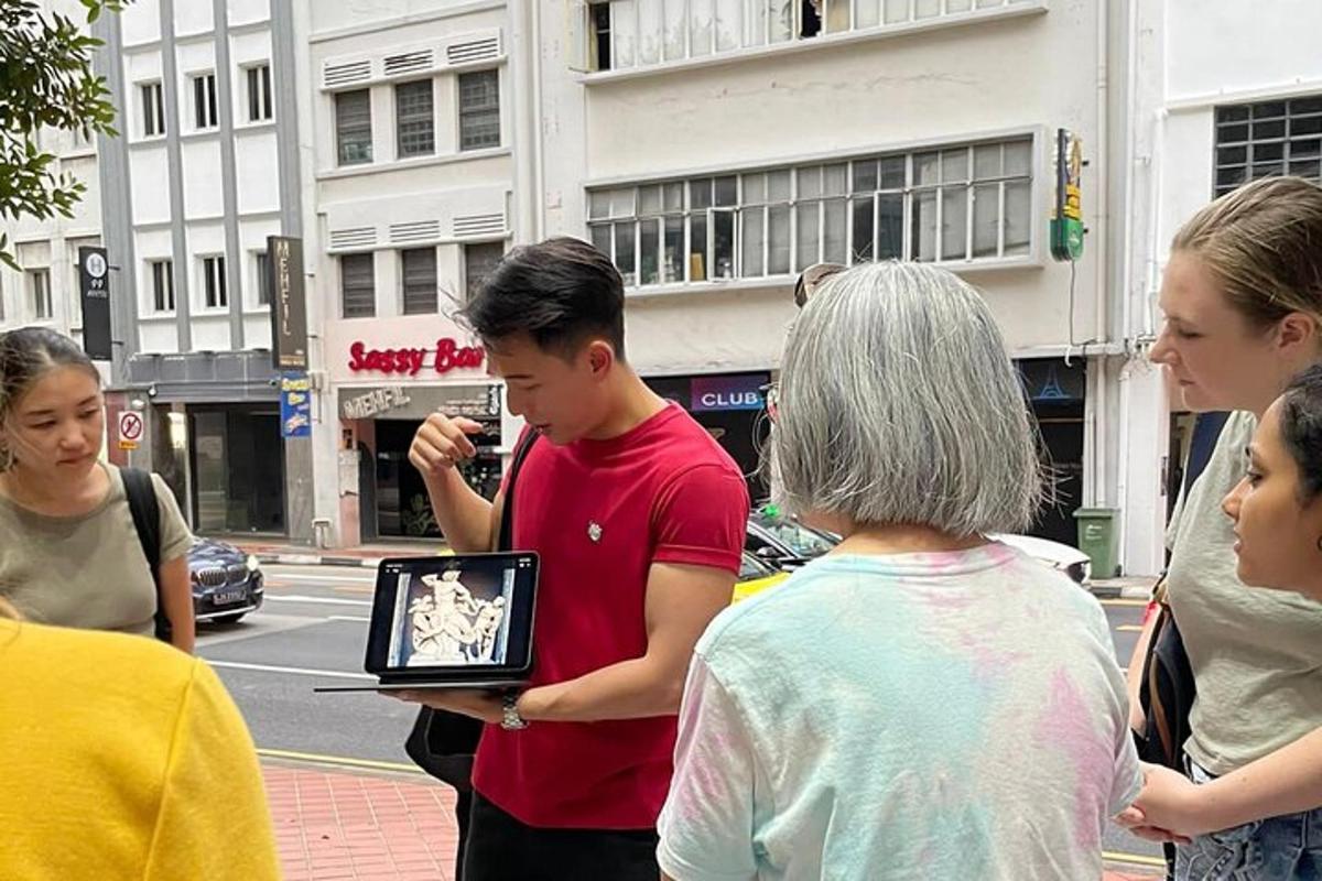 skupina lidí stojících na ulici a dívajících se na notebook