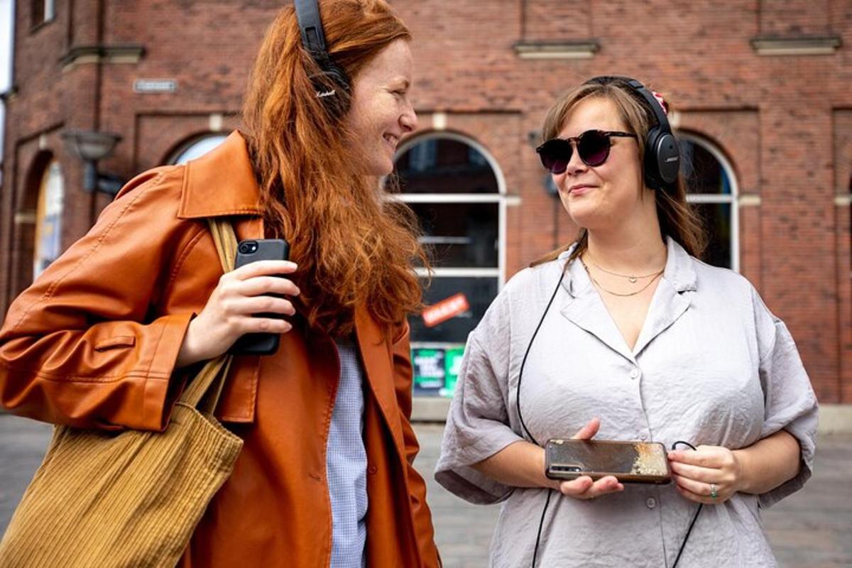 twee vrouwen staan naast elkaar en kijken naar een mobiele telefoon