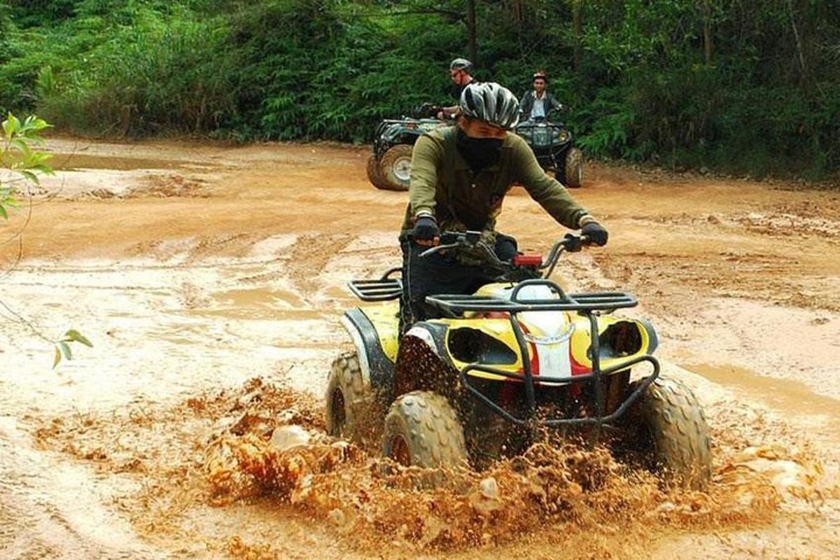 seorang lelaki menunggang kenderaan empat roda melalui padang berlumpur