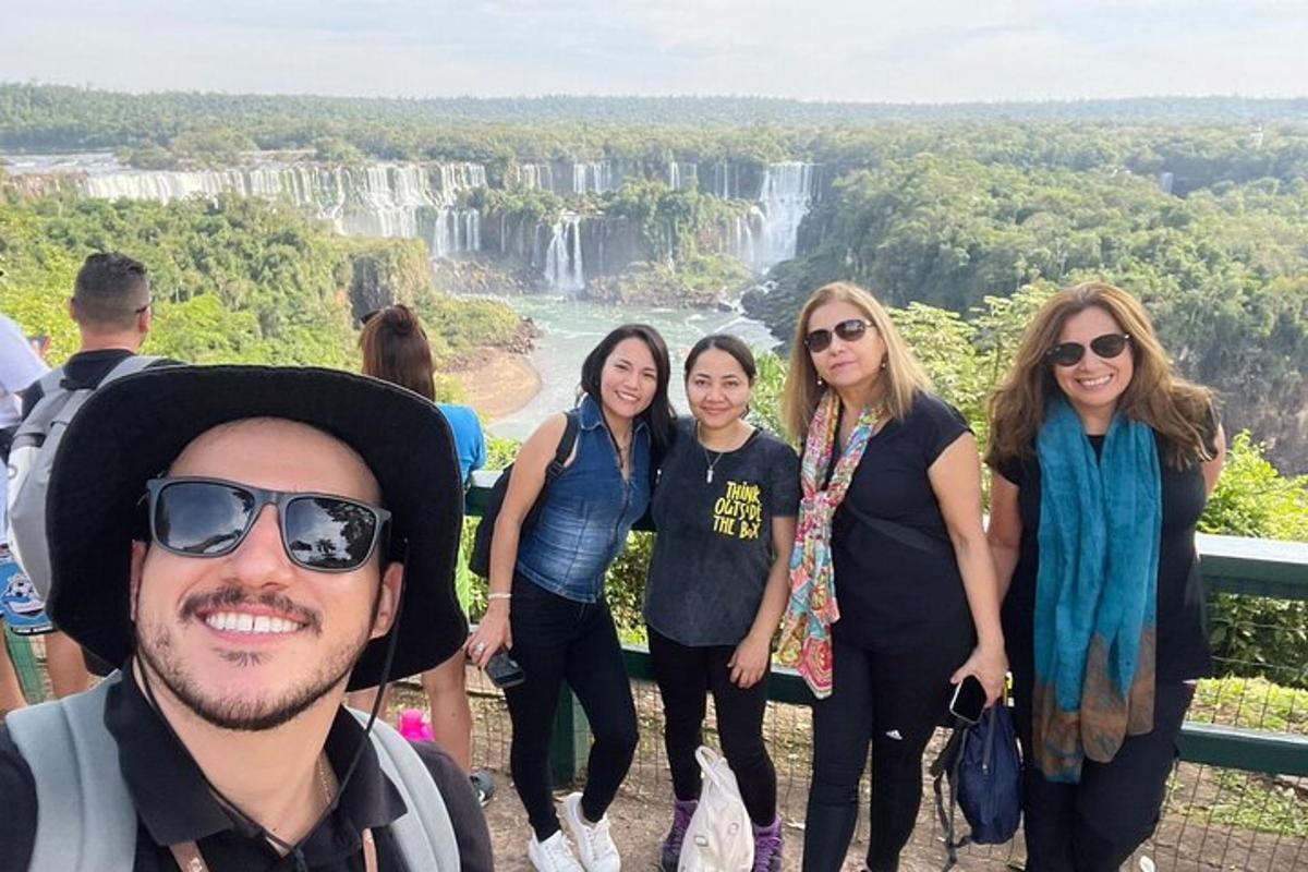 sekumpulan orang berdiri di hadapan air terjun