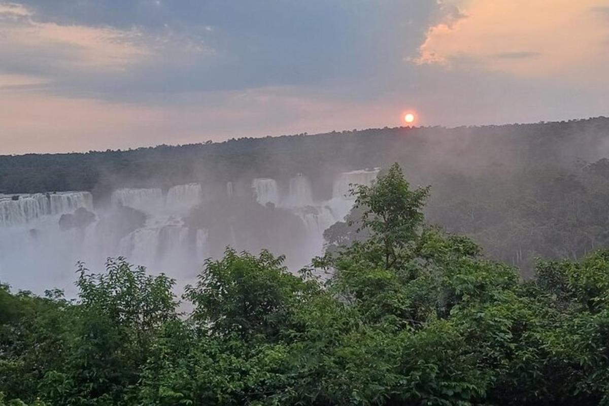 pemandangan air terjun dengan latar belakang matahari