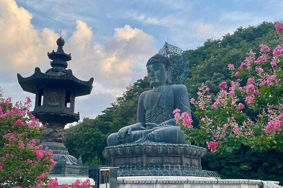uma estátua em um parque com flores rosas
