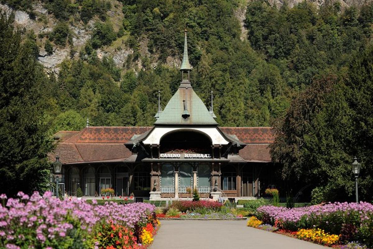a building with a steeple in a garden with flowers