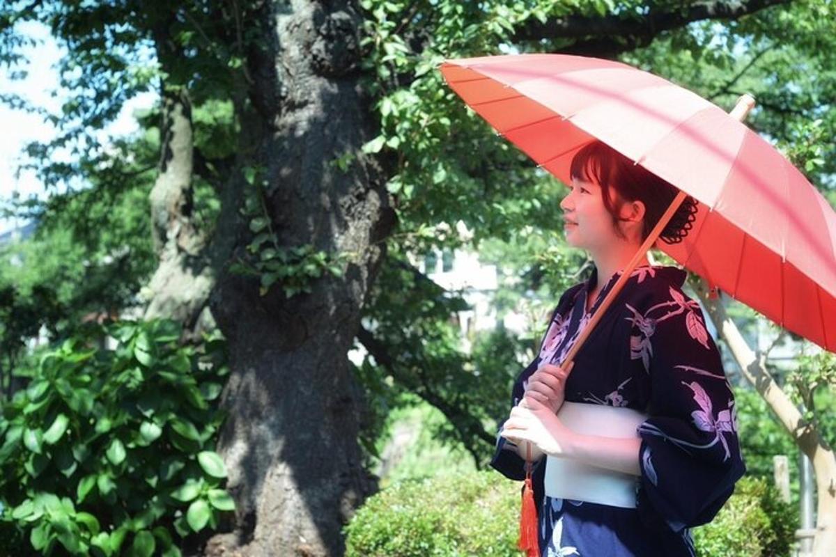 a woman holding a red umbrella in front of a tree