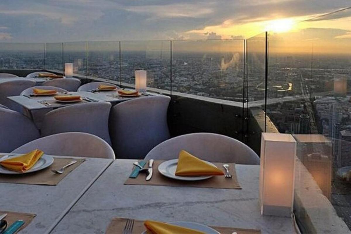un ristorante con tavoli e sedie e vista sulla città