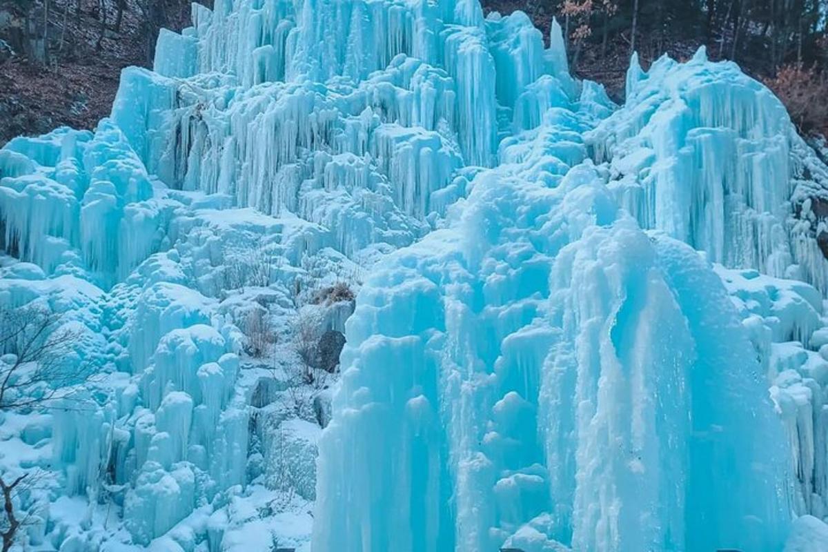 a large blue ice wall with snow on it