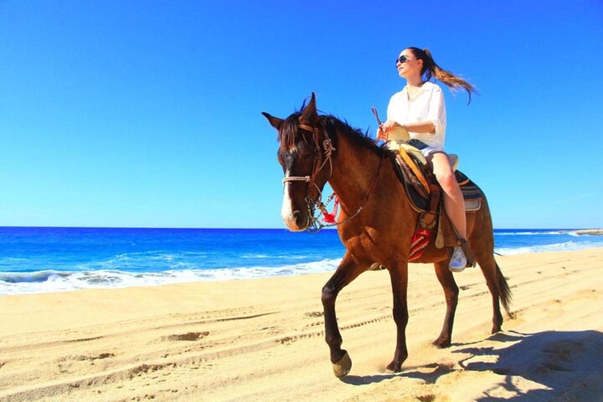 una mujer montando a caballo en la playa