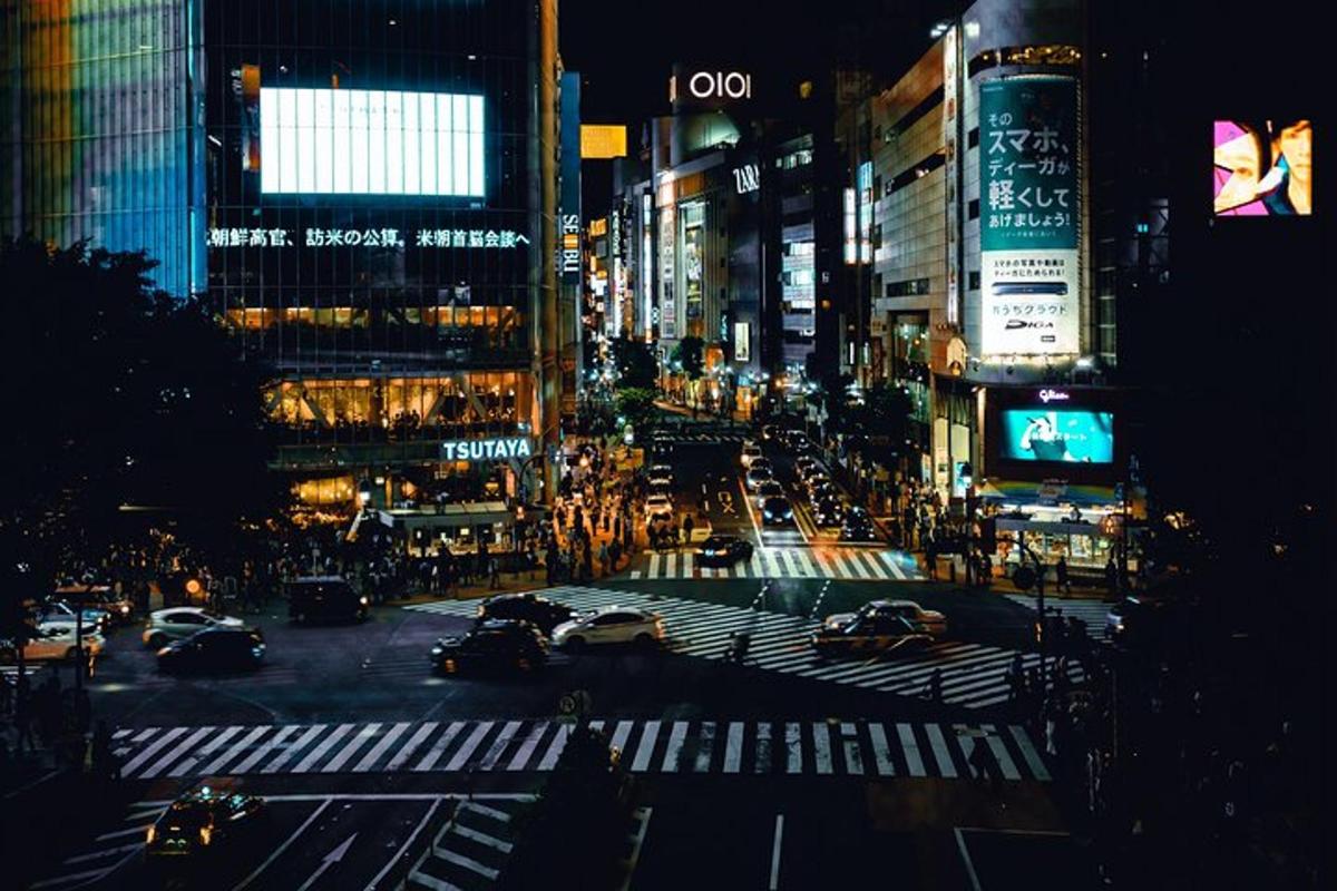 a busy city street at night with cars and buildings