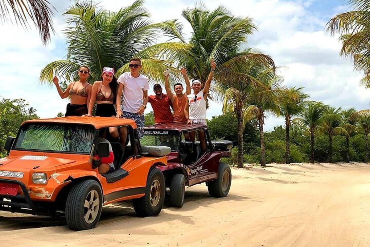 a group of people standing on the back of an orange jeep