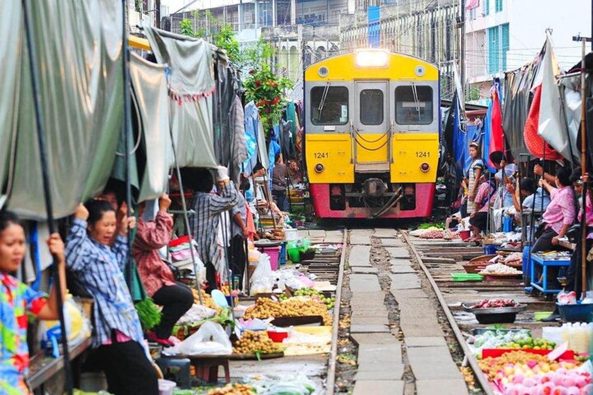 kereta api sedang melalui pasar dengan orang di dalamnya