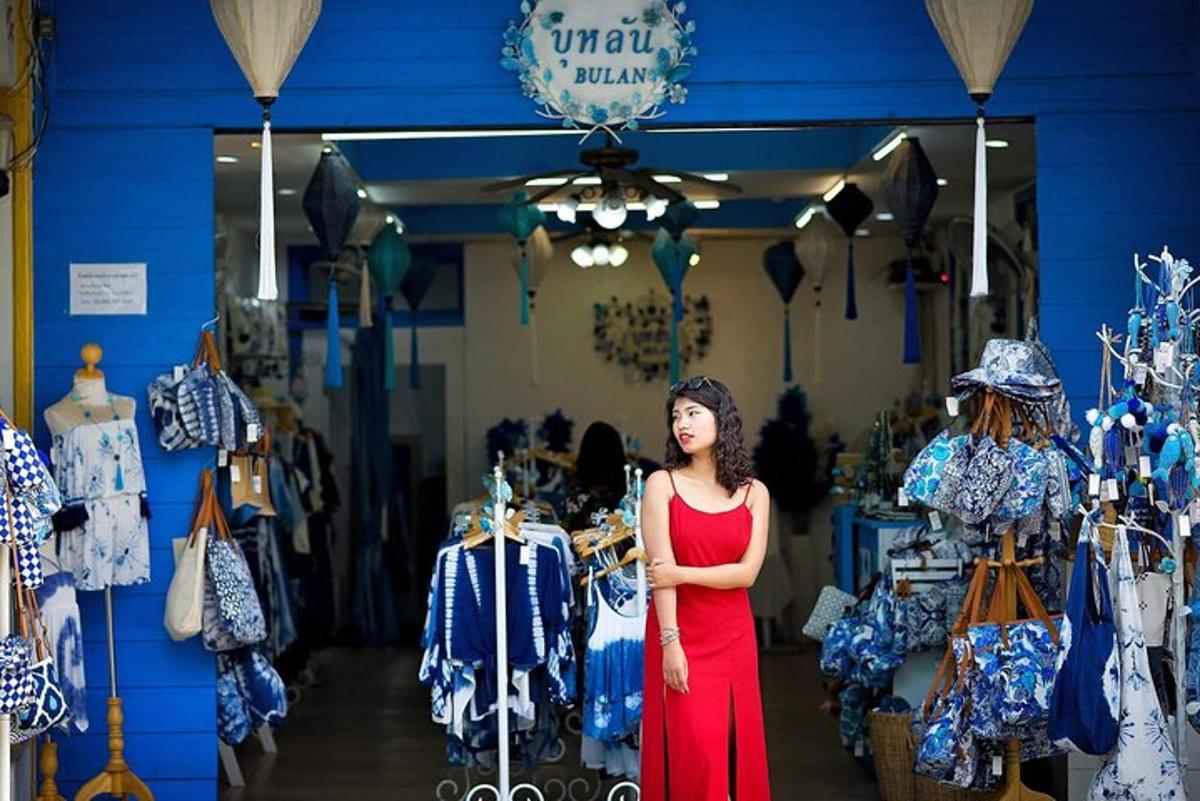 một người phụ nữ đang đứng trước một cửa hàng quần áo