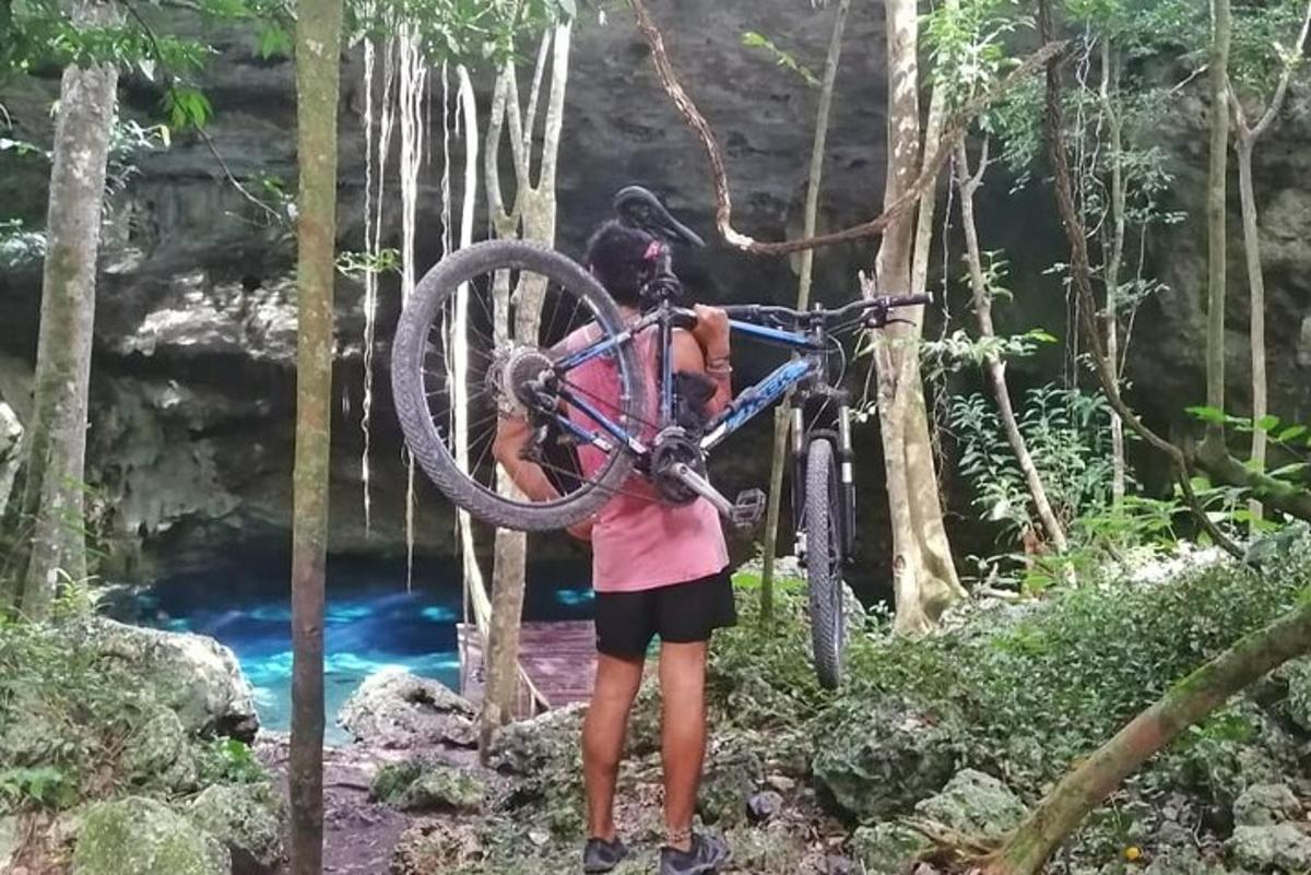 en kvinde, der holder en cykel foran et vandfald