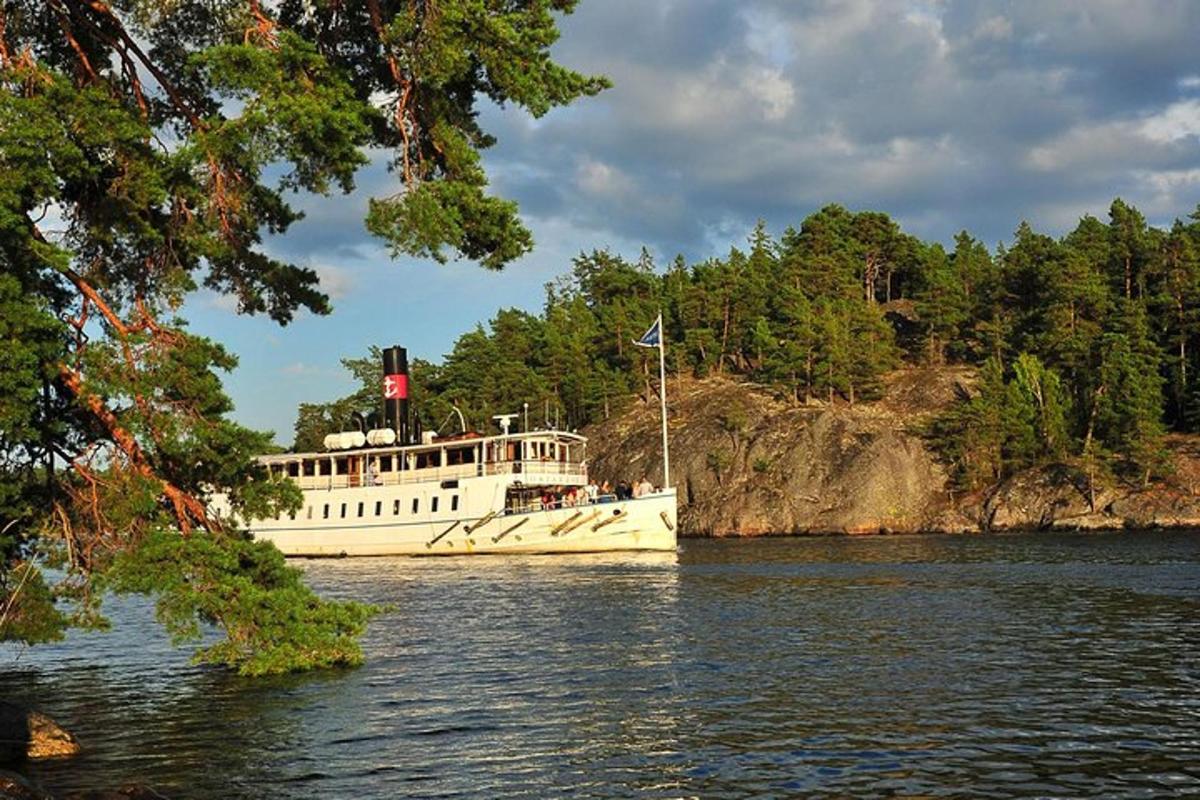 a white boat on the water next to trees