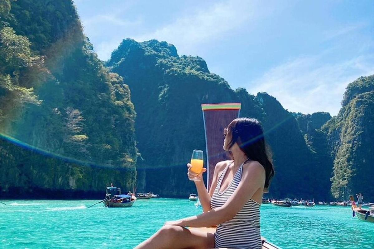 a woman sitting on a boat holding a glass of orange juice