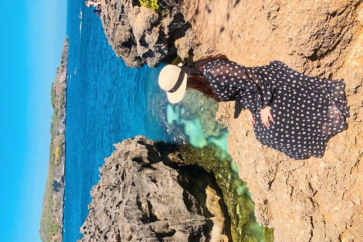 a woman laying on a rock next to the ocean