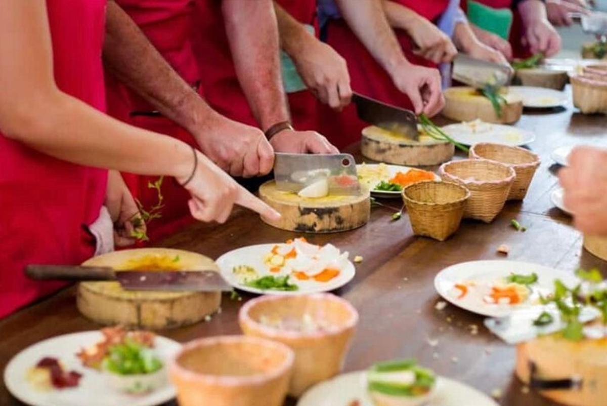 um grupo de pessoas preparando comida em uma mesa