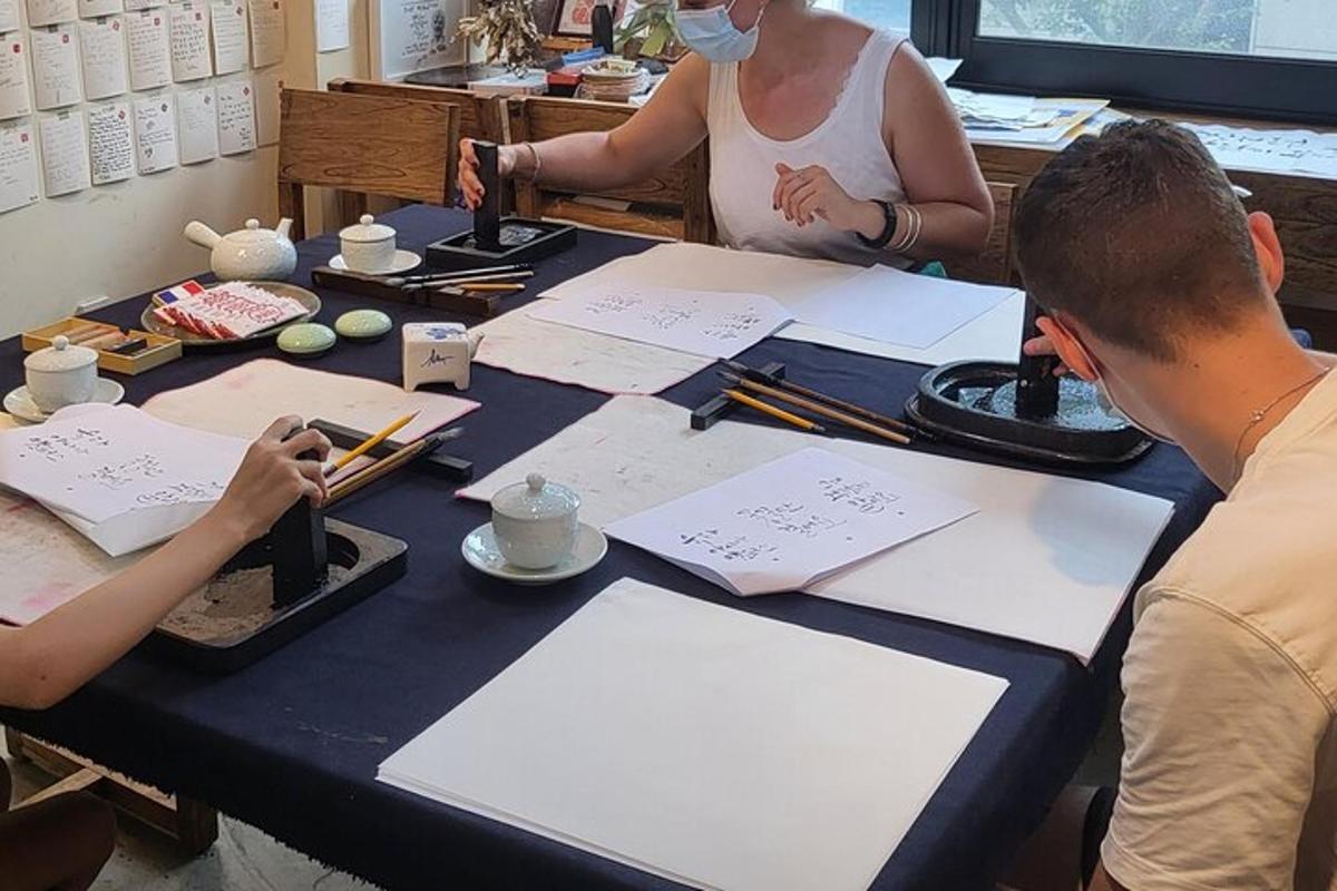 due persone sedute a un tavolo che scrivono su un foglio di carta