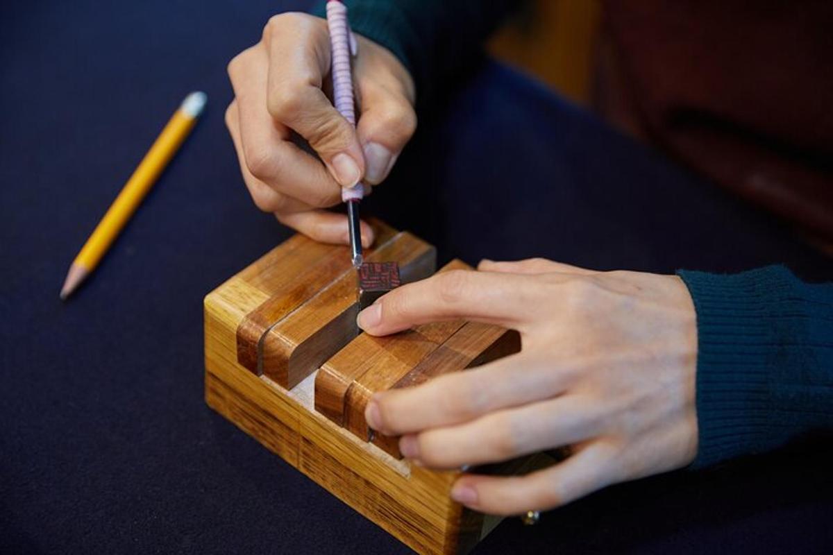 una persona che taglia un pezzo di legno con un coltello