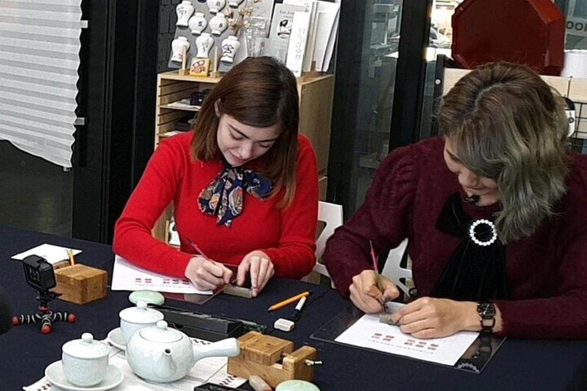 due donne sedute a un tavolo che scrivono su dei fogli