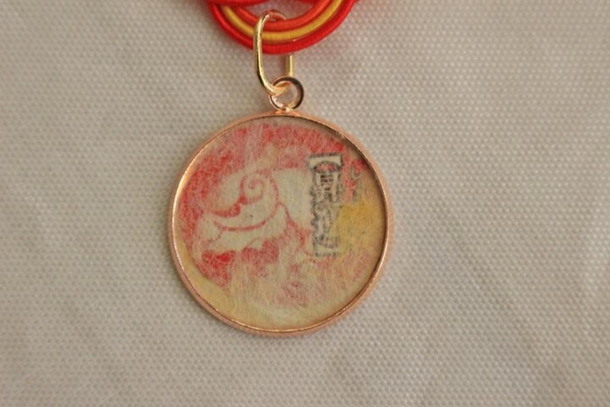un ciondolo d'oro su una catena rossa su un tavolo
