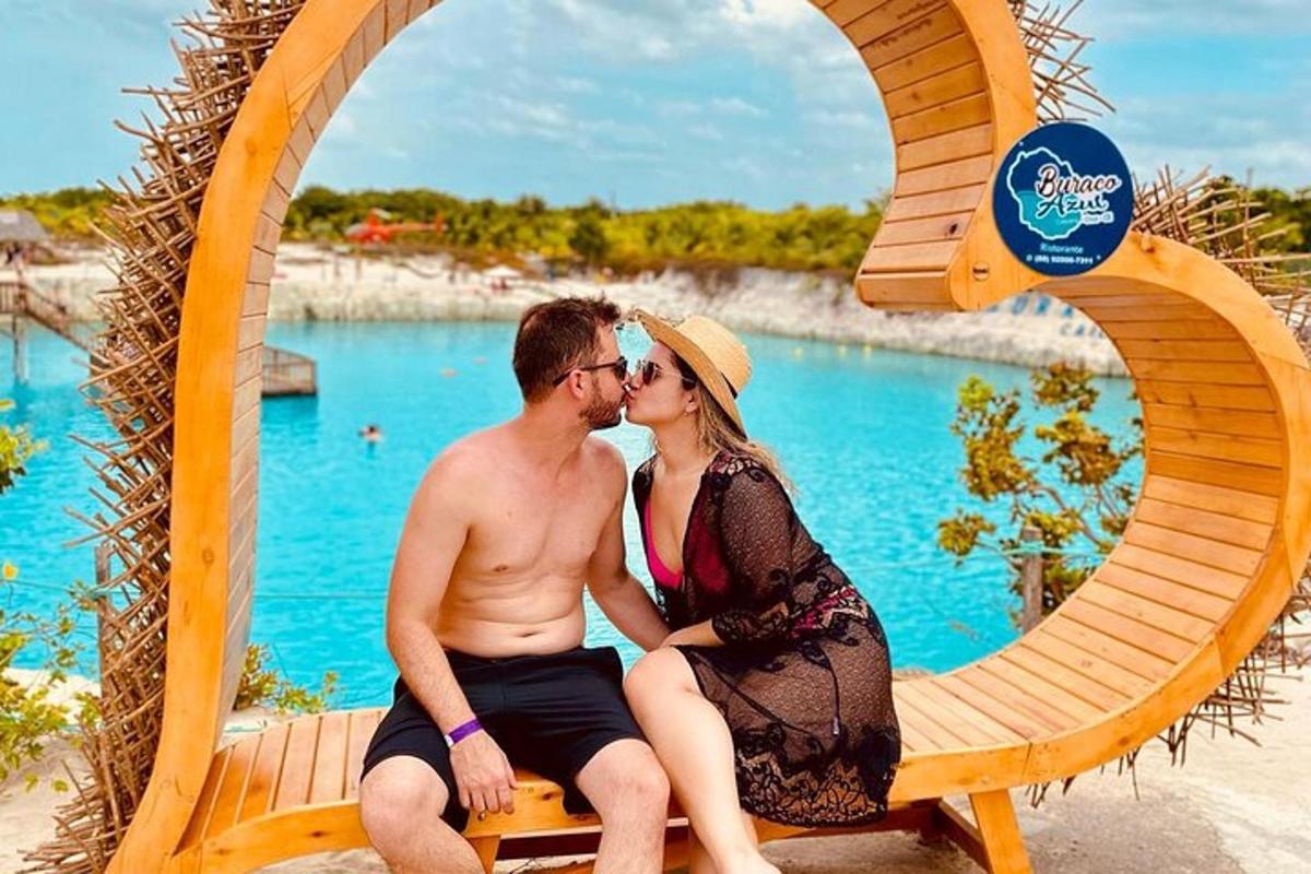moški in ženska sedita na klopi pred vodo