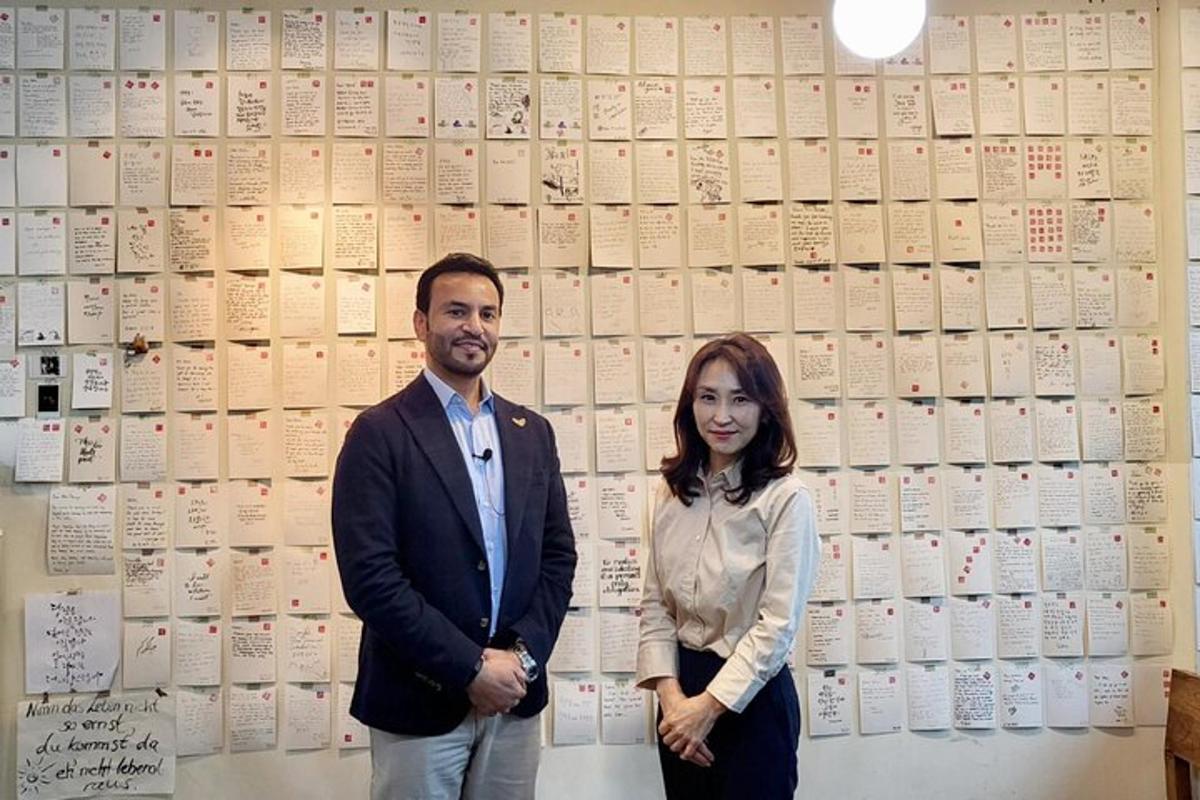 un uomo e una donna in piedi davanti a un muro di libri