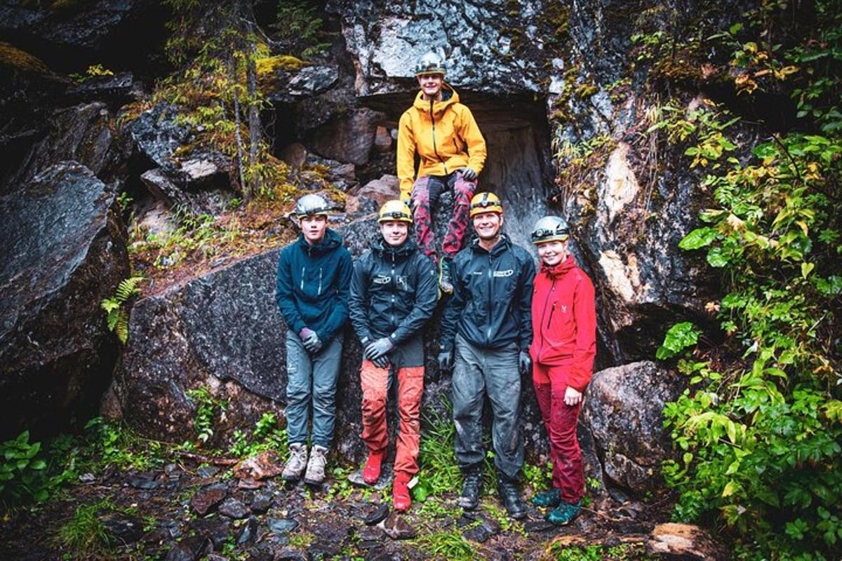 a group of people standing in front of a cave