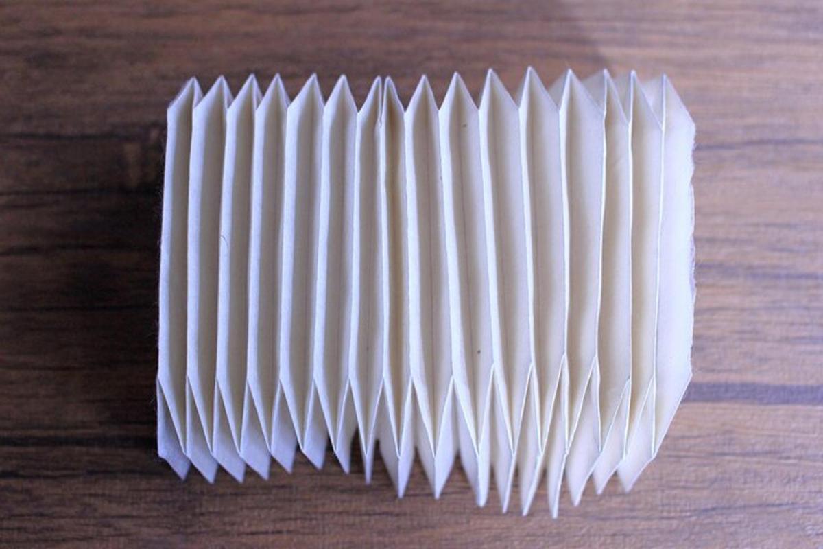 Un objeto de papel blanco sobre una mesa de madera.