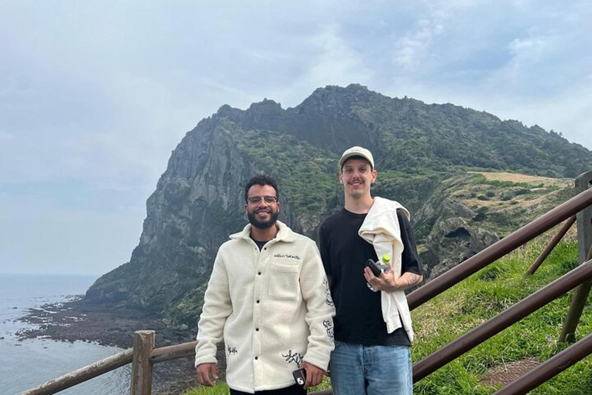 two men are standing in front of a mountain
