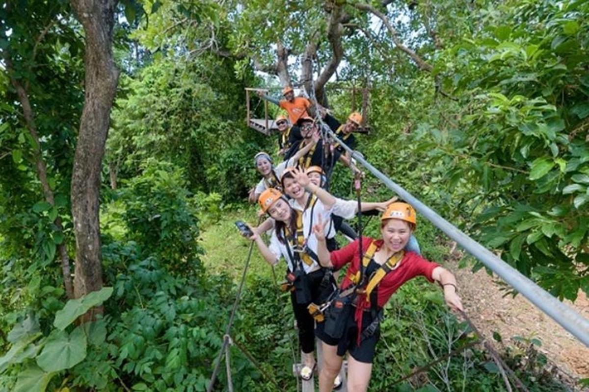 a group of people on a zip line in the forest