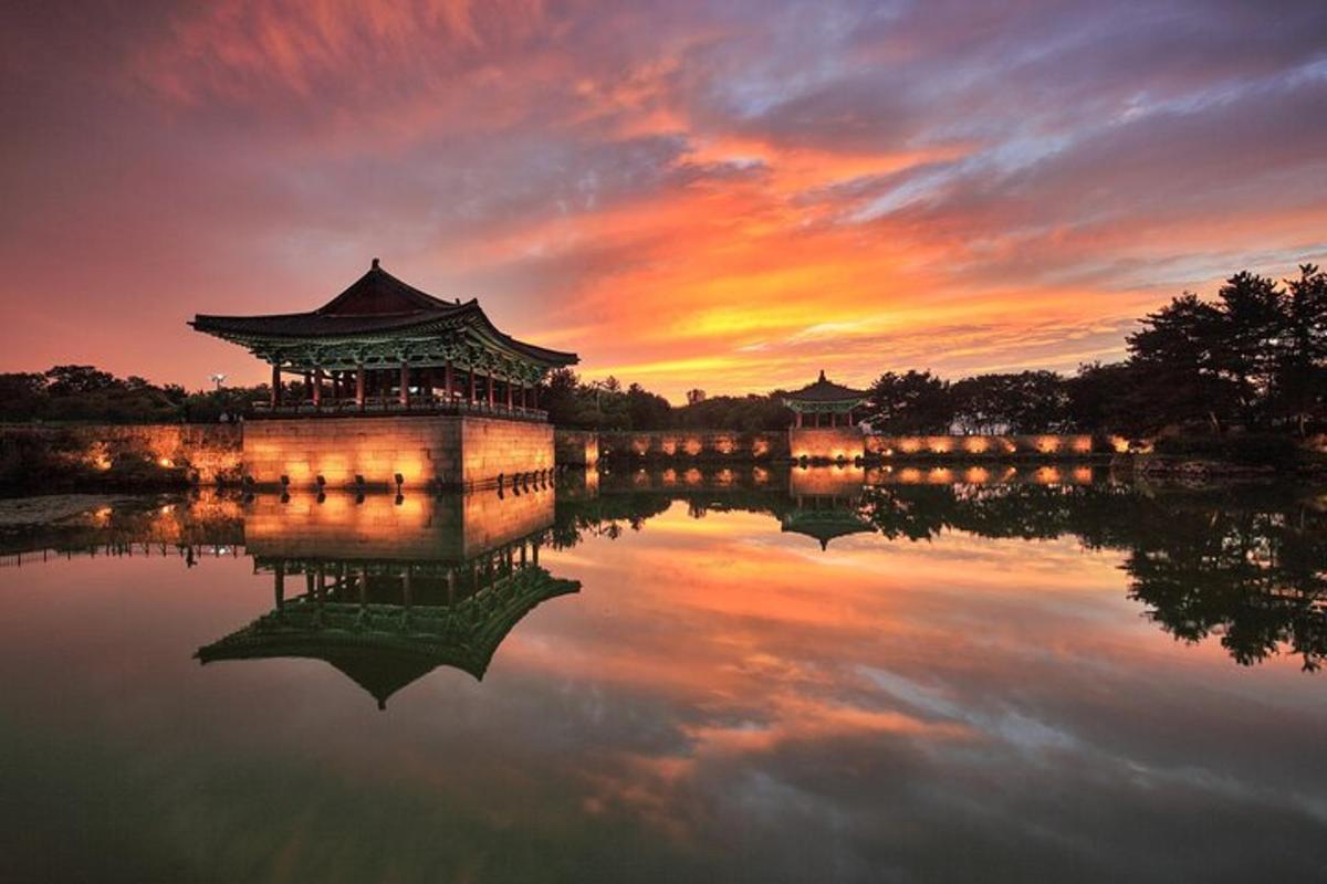 un tramonto su un lago con un edificio cinese